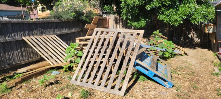 A huge pile of scrap lumber, Pallets, and Construction debris Taking up 1/4th of this customers yard
