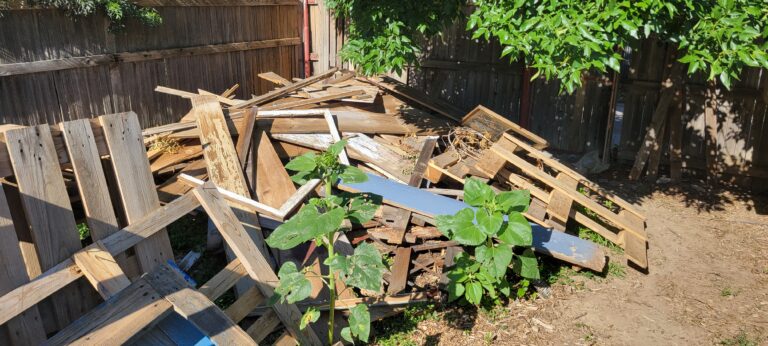 A huge pile of scrap lumber, Pallets, and Construction debris Taking up 1/4th of this customers yard