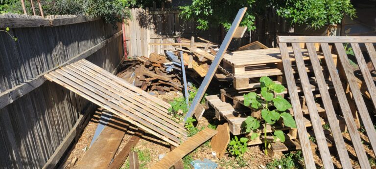 A huge pile of scrap lumber, Pallets, and Construction debris Taking up 1/4th of this customers yard